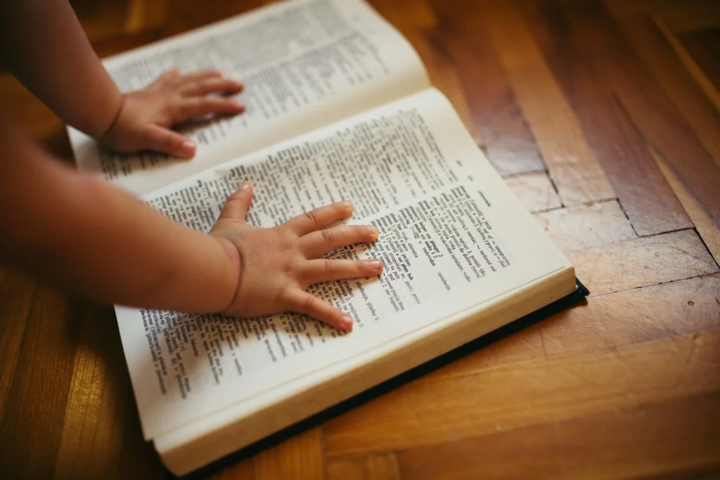 Babyhände auf Wörterbuch